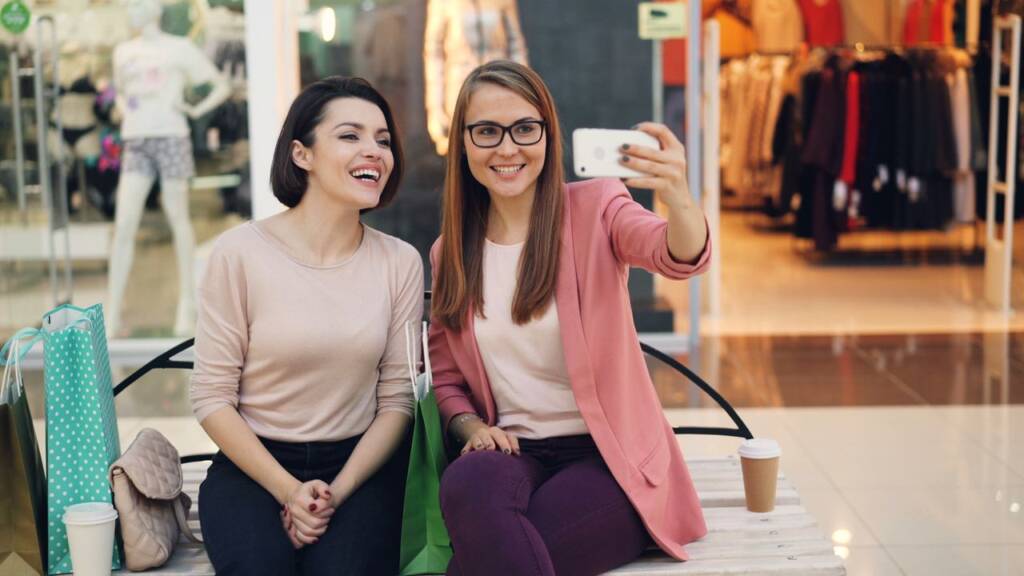Two friends take a selfie while shopping in a retail store