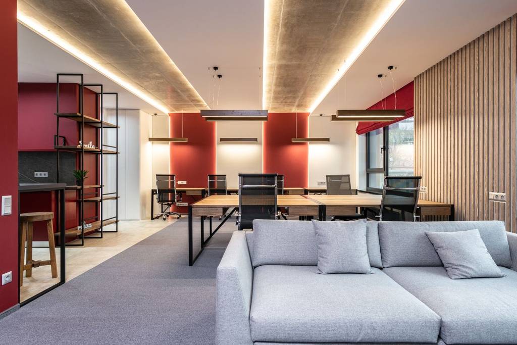 Empty hybrid office space with various desk, sofas and standing desks